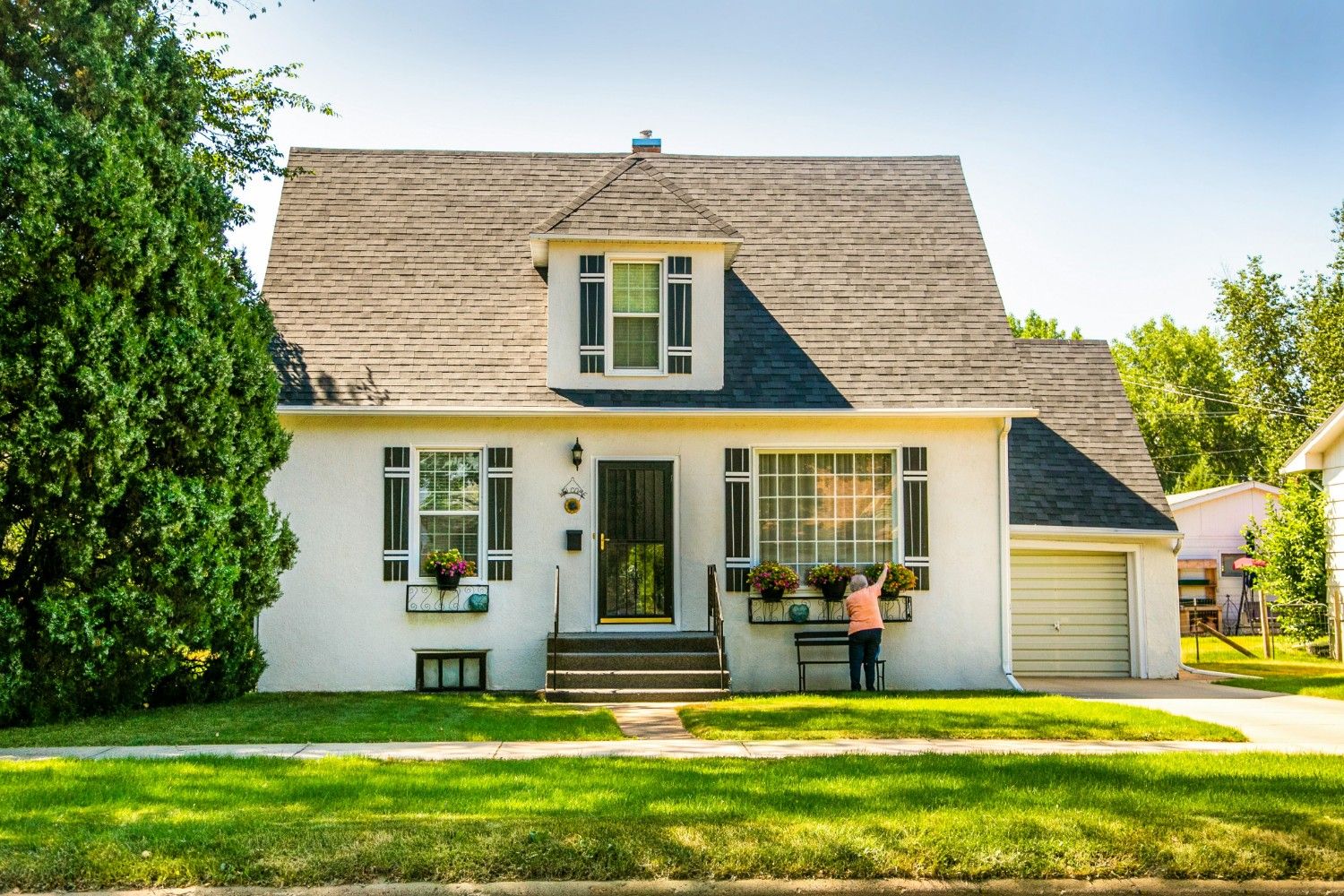 Modern single-family house with sloped roof, front lawn, and large windows in a peaceful residential area