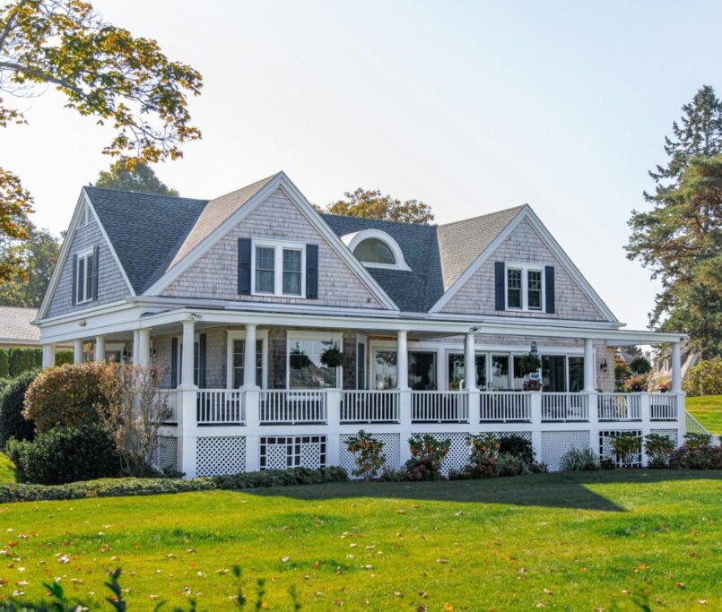 Beautiful modern farmhouse-style home with white exterior, large porch, and landscaped garden